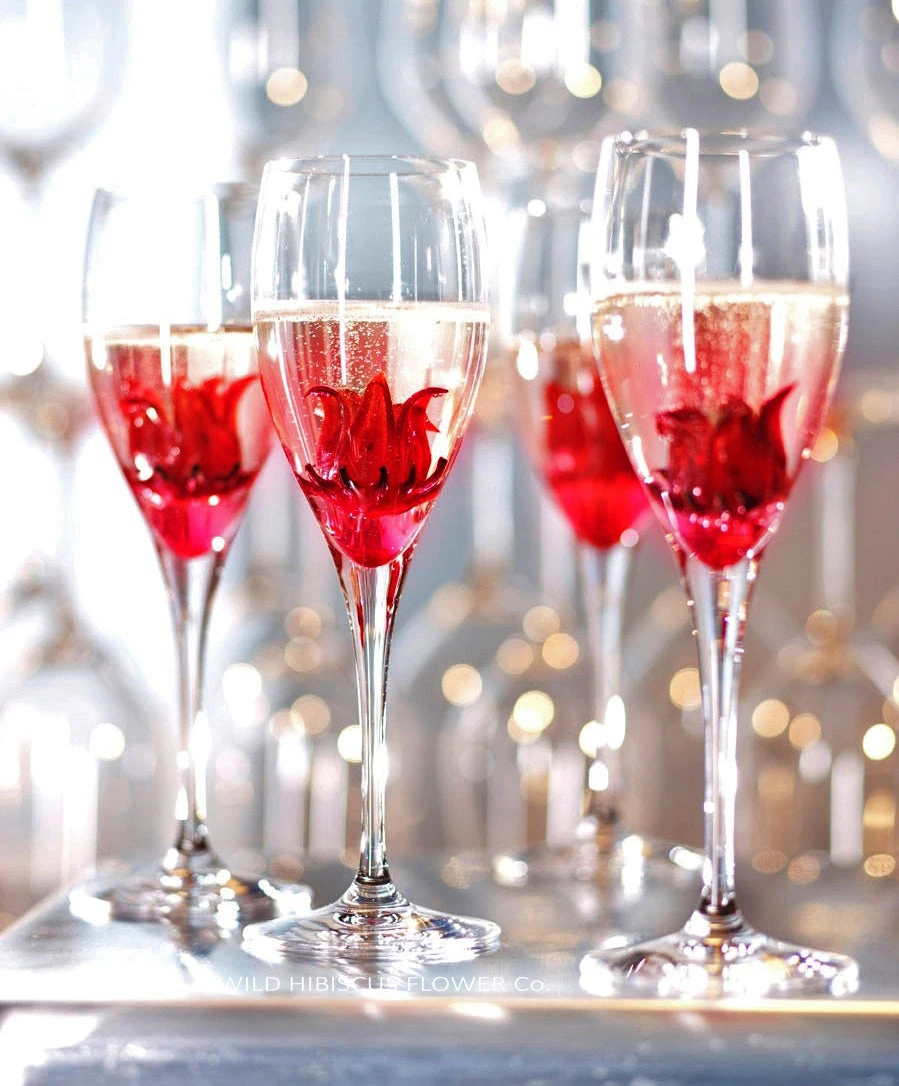 Whole hibiscus flowers served in sparkling wine for a celebration